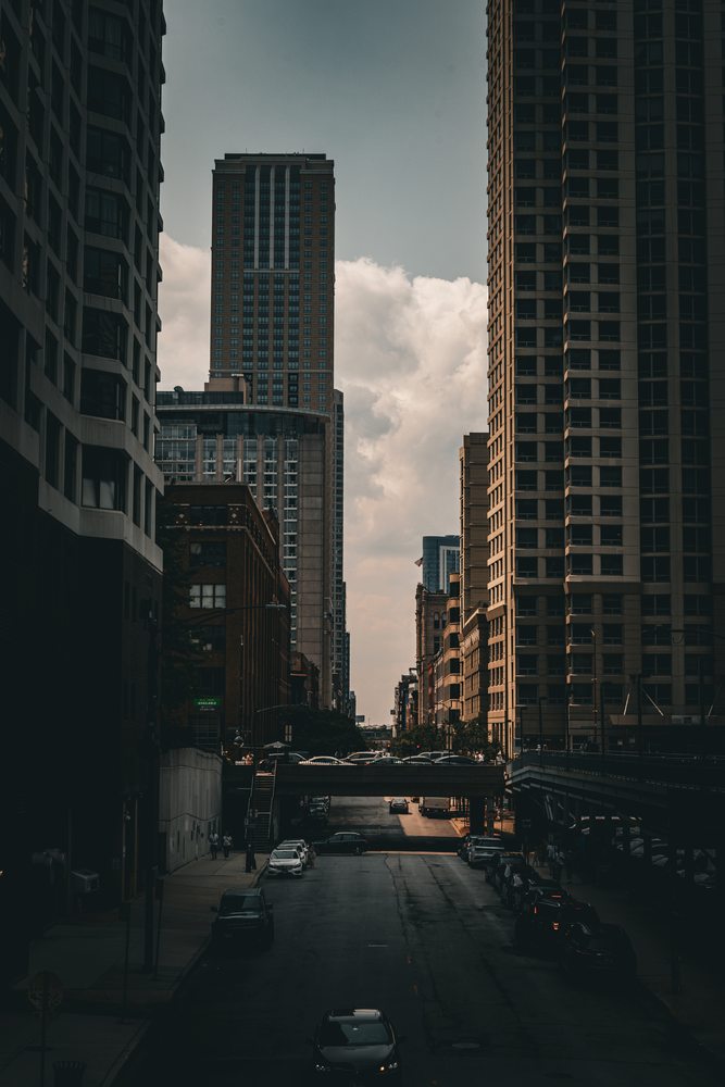 A view along a street between tall buildings in late afternoon light.