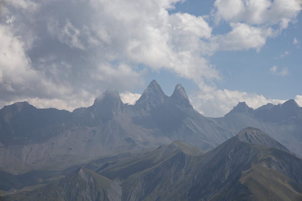 The pointed summits of the Aiguilles d’Arves beneath low, broken clouds.