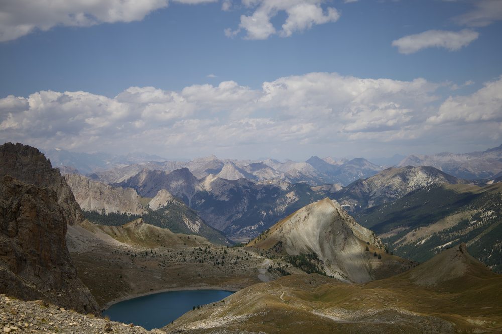 A blue lake among rocky ridges and distant mountain ranges.